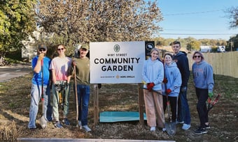 Seven Quantum Workplace employees volunteering at a community garden.