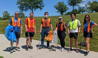 Six Quantum Workplace employees volunteering with litter cleanup.