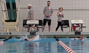 2 Quantum Workplace employees volunteering at the Special Olympics at a swim meet
