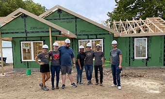Seven Quantum Workplace employees volunteering to build a house