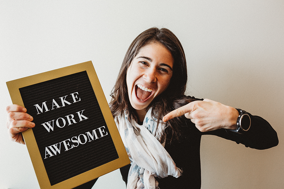 Quantum Workplace employee holding a sign that says make work awesome
