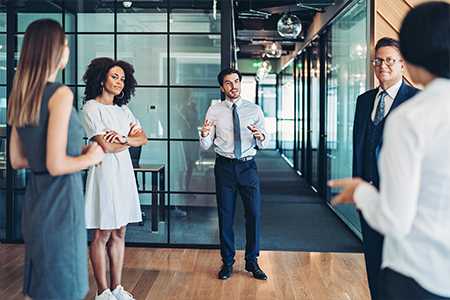 Group of employees standing and talking with each other happily