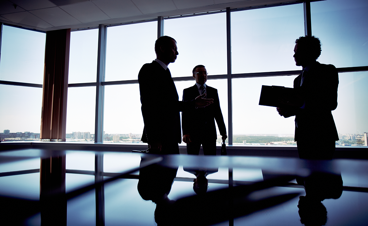 Three leaders gathered in a conference room to discuss building belief in organizational change