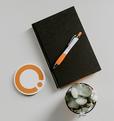 Quantum workplace sticker and pen on top of a black notebook